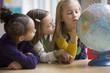 Students looking at globe in classroom