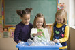 Students recycling plastic bottles in classroom