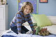 Caucasian boy playing with dinosaurs on bed