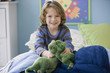 Caucasian boy playing with dinosaurs on bed