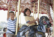 Excited brothers riding carousel