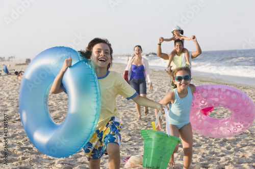 Photo: Hispanic family enjoying beach together Hispanic family enjoying beach together