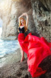 The beautiful red-haired girl poses on a sandy beach