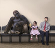 Caucasian girl offering banana to gorilla