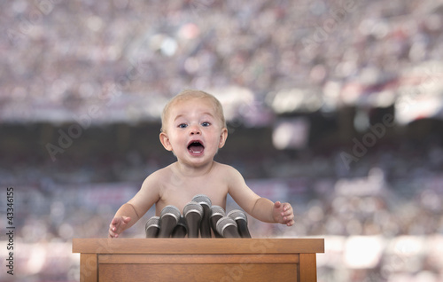 Photo: Caucasian baby speaking at podium Caucasian baby speaking at podium