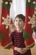 Caucasian boy looking at Christmas stockings