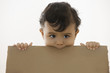 Mixed race baby boy holding piece of cardboard