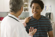 Doctor talking to boy in doctor's office