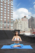 Mixed race woman practicing yoga on rooftop