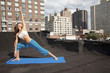 Mixed race woman practicing yoga on rooftop