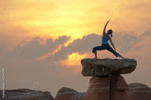 Photo: Caucasian woman practicing yoga on top of rock formation Caucasian woman practicing yoga on top of rock formation