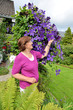 Seniorin mit Kletterpflanze Clematis