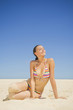 Caucasian woman sitting on beach