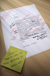 Stick note on paperwork covered with revisions