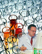 Scientist working in laboratory with test tube design behind him