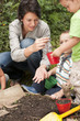 Hispanic mother gardening with sons