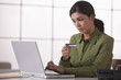 Hispanic woman shopping online with credit card