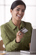 Hispanic woman shopping online with credit card