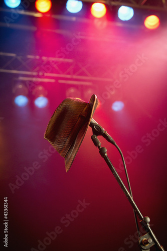 Photo: Fedora hanging on microphone on stage Fedora hanging on microphone on stage