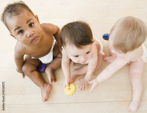 Photo: Babies playing together on floor Babies playing together on floor