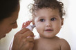 Doctor examining baby girl's ear