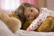 Serious mixed race girl hugging teddy bear