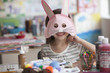 Caucasian girl making rabbit mask
