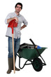 Man stood with spade and wheelbarrow