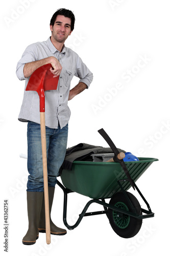 Photo: Man stood with spade and wheelbarrow Man stood with spade and wheelbarrow