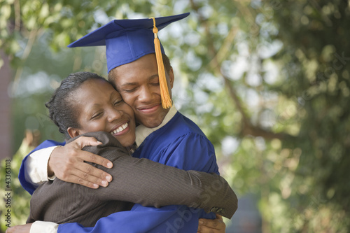 Photo: Proud mother hugging graduating son Proud mother hugging graduating son