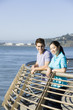 Couple leaning on railing at waterfront