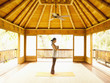 Foto: Profile of woman standing in prayer position inside yoga and meditation pagoda at a luxury resort Profile of woman standing in prayer position inside yoga and meditation pagoda at a luxury resort