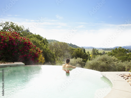 Photo: Man at a luxury resort in infinity pool overlooking Napa Valley, California Man at a luxury resort in infinity pool overlooking Napa Valley, California