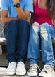 Close up of teenagers jeans as they sit together