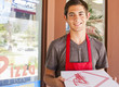 Caucasian teenager holding pizza box in restaurant