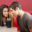 Teenage couple sharing a soda in a restaurant