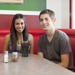 Teenage couple sitting together in restaurant