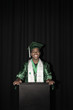 Mixed race high school graduate standing at podium