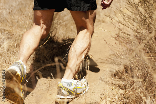 Photo: Hispanic man running on dirt road Hispanic man running on dirt road