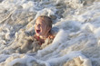 Laughing Caucasian girl in ocean waves