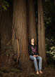 Caucasian woman sitting on tree trunk in forest