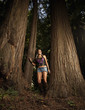 Caucasian woman leaning against tree trunk