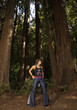 Woman in bell bottoms standing in forest