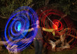 Black woman making blue and red light streaks in air