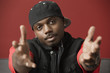 Black man in baseball cap with arms outstretched