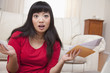 Frustrated Asian woman holding letters