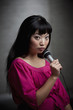 Asian woman singing into microphone