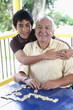Photo: Grandfather and grandson playing dominoes Grandfather and grandson playing dominoes