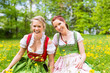 Junge Frauen in traditionellem Dirndl auf einer Frühlingswiese