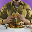 Overweight man eating hamburgers and french fries
